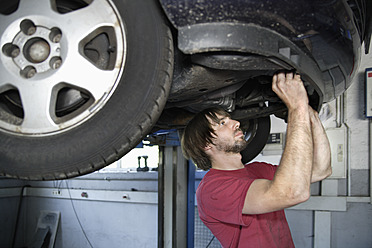 Germany, Ebenhausen, Mechatronic technician working in car garage - TCF001630