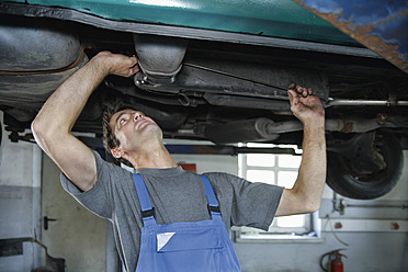 Germany, Ebenhausen, Mechatronic technician working in car garage - TCF001635