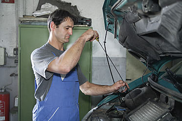 Germany, Ebenhausen, Mechatronic technician working in car garage - TCF001642