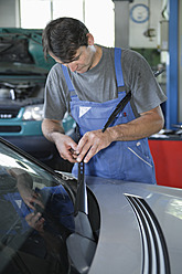 Germany, Ebenhausen, Mechatronic technician working in car garage - TCF001649