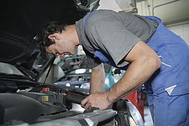 Germany, Ebenhausen, Mechatronic technician working in car garage - TCF001650