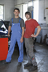 Germany, Ebenhausen, Mechatronic Technicians standing in repair garage, portrait - TCF001659