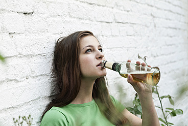 Deutschland, Berlin, Junge Frau trinkt Bier aus Bierflasche - WESTF016923