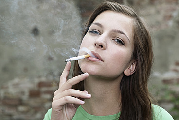 Deutschland, Berlin, Nahaufnahme einer jungen Frau beim Rauchen, Porträt - WESTF016929