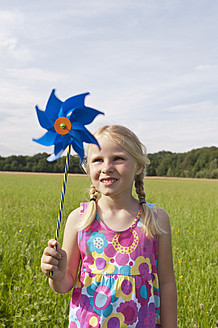 Deutschland, Nordrhein-Westfalen, Hennef, Mädchen stehend mit Windmühle in Wiese - KJF000144