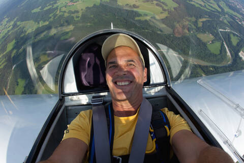 Germany, Bavaria, Bad Toelz, Mature man in glider, smiling, portrait stock photo