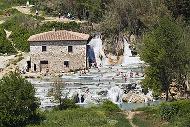 Italien, Toskana, Provinz Grosseto, Saturnia, Blick auf Menschen an Thermalwasserfällen und Travertinbecken - FOF003502