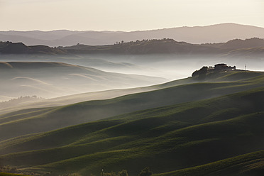 Italien, Toskana, Kreta, Blick auf Bauernhof mit Nebel in hügeliger Landschaft - FOF003546
