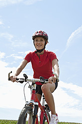 Germany, Bavaria, Young woman riding mountain bike - MAEF003672