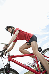 Germany, Bavaria, Young woman riding mountain bike - MAEF003665