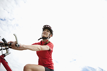 Germany, Bavaria, Young woman riding mountain bike - MAEF003664