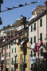 Italy, Liguria, Riomaggiore, Cinque Terre, View of village buildings with bunting - GWF001539