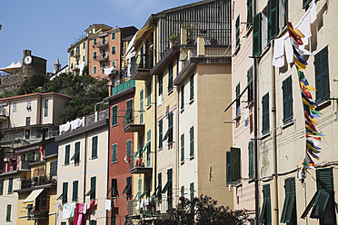 Italy, Liguria, Riomaggiore, Cinque Terre, View of village buildings with bunting - GWF001540