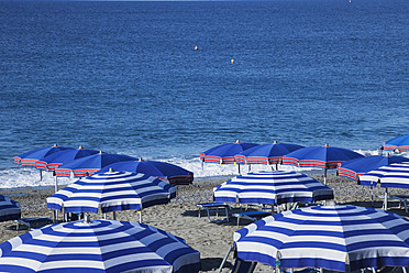 Italy, Liguria, Cinque Terre, Deiva Marina, View of parasol and sunbeds on beach of Mediteranean Ocean - GWF001550