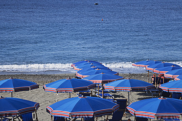 Italy, Liguria, Cinque Terre, Deiva Marina, View of parasol and sunbeds on beach of Mediteranean Ocean - GWF001552