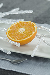 Weihnachtsdekoration neben einer halbierten Orange auf einem Teller, Nahaufnahme - ASF004405
