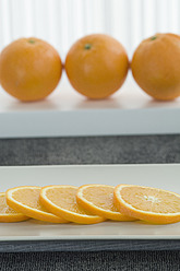 Ganze Orange mit Scheiben auf Teller, Nahaufnahme - ASF004394