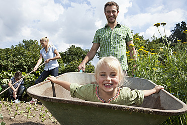 Deutschland, Bayern, Altenthann, Familie gärtnert gemeinsam im Garten - RBF000694