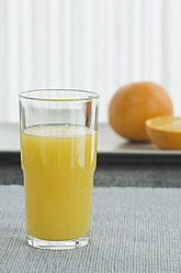 Glas Orangensaft mit Orange auf dem Tisch - ASF004410