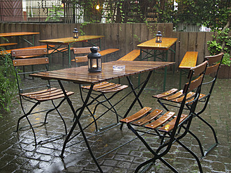 Deutschland, Hessen, Frankfurt, Leerer Tisch und Stühle nass im Regenwasser im Garten - MU001043