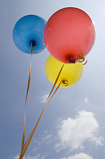 Germany, Bavaria, Three coloured balloons in blue sky - CRF002102
