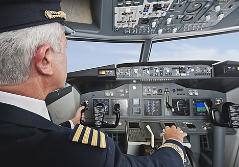 Deutschland, Bayern, München, Senior Flugkapitän steuert Flugzeug aus dem Cockpit - WESTF017016