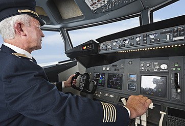 Germany, Bavaria, Munich, Senior flight captain piloting aeroplane from airplane cockpit - WESTF017017