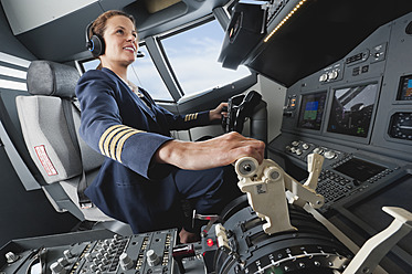 Deutschland, Bayern, München, Frau Flugkapitän steuert Flugzeug aus dem Cockpit - WESTF017037