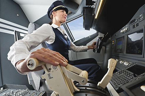 Germany, Bavaria, Munich, Woman flight captain piloting aeroplane from airplane cockpit - WESTF017039