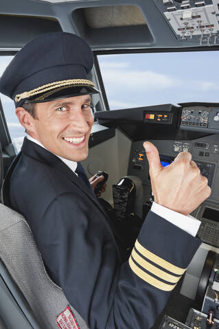 Deutschland, Bayern, München, Pilot mit Daumen hoch im Cockpit eines Flugzeugs, lizenzfreies Stockfoto