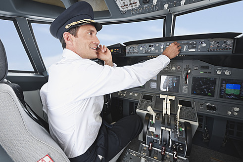 Deutschland, Bayern, München, Pilot benutzt Mobiltelefon und steuert Flugzeug vom Cockpit aus - WESTF017058
