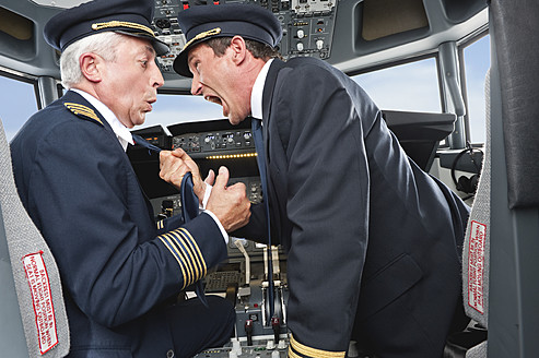 Germany, Bavaria, Munich, Pilot and co-pilot fighting in airplane cockpit - WESTF017069