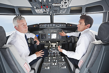 Deutschland, Bayern, München, Pilot und Co-Pilot steuern Flugzeug aus dem Cockpit des Flugzeugs - WESTF017075