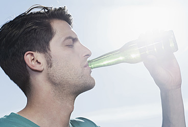 Spain, Majorca, Young man drinking beer, close up - WESTF017107