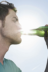 Spanien, Mallorca, Junger Mann trinkt Bier, Nahaufnahme - WESTF017108