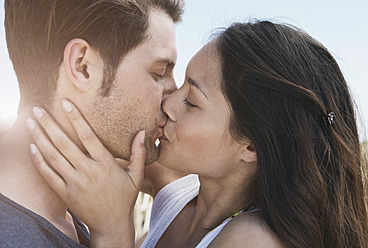 Spain, Majorca, Young couple kissing on boardwalk, close up - WESTF017127