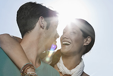 Spain, Majorca, Young couple romancing in sunlight, smiling - WESTF017150