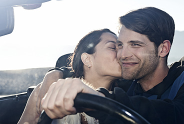 Spain, Majorca, Young woman kissing man in cabriolet car, close up - WESTF017169