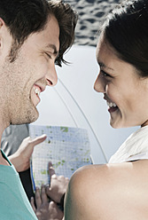 Spanien, Mallorca, Junges Paar hält Karte, lächelnd - WESTF017176