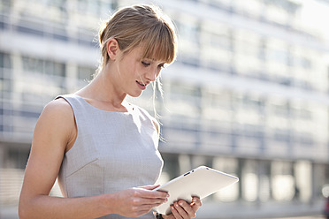 Germany, Bavaria, Munich, Young businesswoman with digital tablet - MAEF003734