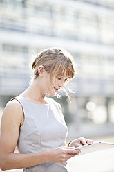 Germany, Bavaria, Munich, Young businesswoman with digital tablet - MAEF003731