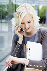 Germany, Bavaria, Munich, Young woman on phone and watching time - SPOF000035