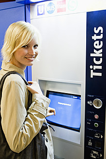 Deutschland, Bayern, München, Junge Frau an Fahrkartenautomat in U-Bahn-Station - SPOF000006