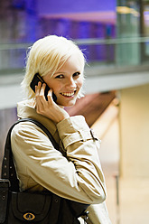 Germany, Bavaria, Munich, Young woman on phone, smiling, portrait - SPOF000008