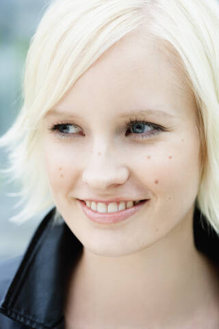 Germany, Bavaria, Munich, Young woman looking away, smiling stock photo