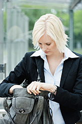 Germany, Bavaria, Munich, Young woman looking into her handbag - SPOF000028