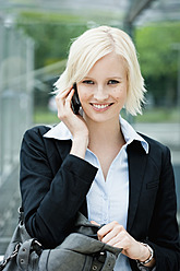 Germany, Bavaria, Munich, Young woman on phone, smiling, portrait - SPOF000030