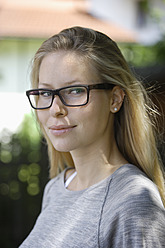 Deutschland, Bayern, Schaeftlarn, Junge Frau mit dickrandiger Brille, lächelnd, Nahaufnahme - TCF001726