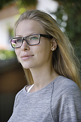 Deutschland, Bayern, Schaeftlarn, Junge Frau mit dickrandiger Brille, lächelnd, Nahaufnahme - TCF001728