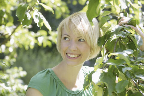 Germany, Bavaria, Schaeftlarn, Close up of young woman in park, smiling stock photo